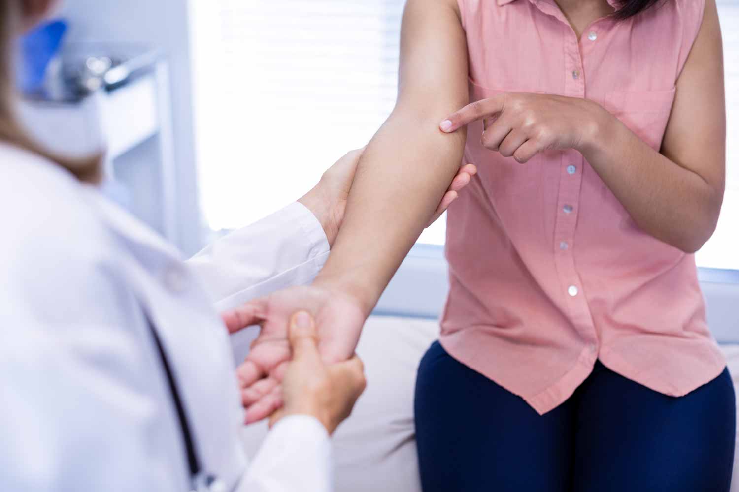 women with pain in her arm showing doctor